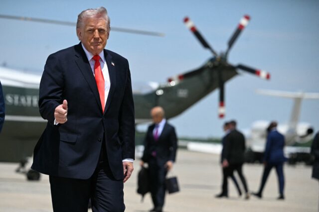 US President Donald Trump flashes a thumbs up while walking to board Air Force One at Join