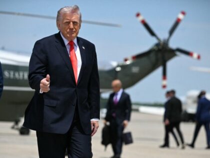 US President Donald Trump flashes a thumbs up while walking to board Air Force One at Join