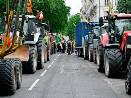 Several dozen Rural Coordination farmers are gathered between two rows of tractors parked
