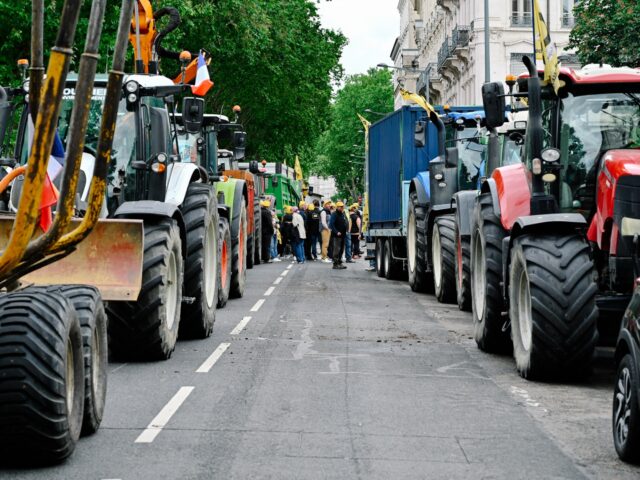 Several dozen Rural Coordination farmers are gathered between two rows of tractors parked
