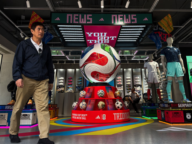 GettyImages-2278305294 HONG KONG, CHINA - MAY 26: A customer walks past a display featuring the official match ba