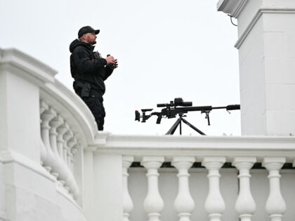 A member of the US Secret Service stands watch on the roof of the White House before US Pr