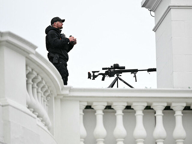 A member of the US Secret Service stands watch on the roof of the White House before US Pr