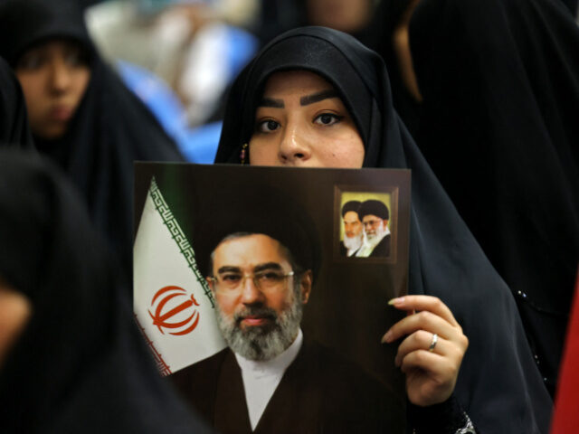Iran Supreme Leader Poster An Iranian woman holds an image of Iran's supreme leader Mojtaba Khamenei, as she and
