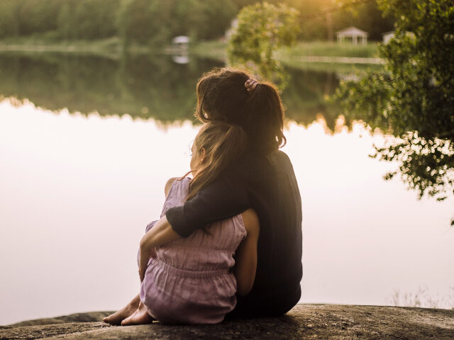 Mother and daughter embracing outside
