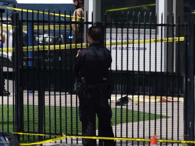 A body is covered with a tarp at the scene of a shooting outside the Islamic Center of San