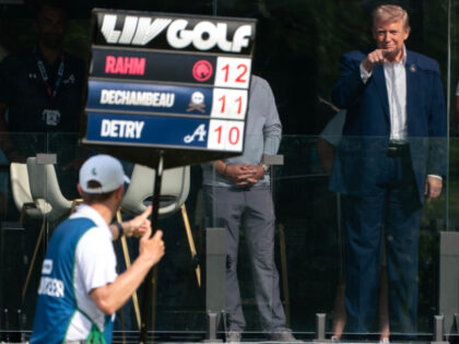 U.S. President Donald Trump greets a scorer participating in the LIV Golf tournament at Tr