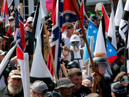 FILE - White nationalist demonstrators walk into the entrance of Lee Park surrounded by co