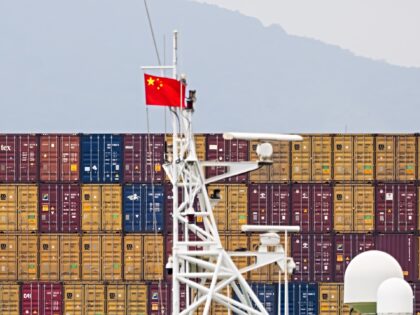 SHENZHEN, CHINA - MAY 7: A Chinese national flag is seen near stacked shipping containers