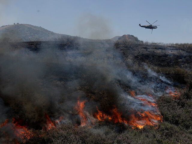 SIMI VALLEY, CALIFORNIA - MAY 18: A firefighting helicopter flies over the Sandy Fire as i