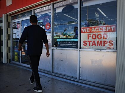 MIAMI, FLORIDA - OCTOBER 31: A 'We Accept Food Stamps' sign hangs in the window of a groce