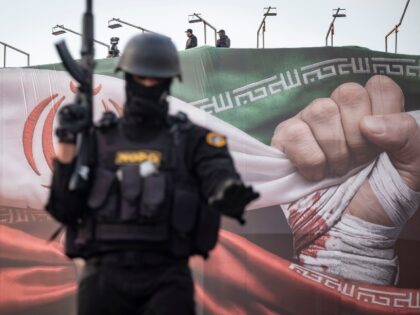 Armed members of Iran's police special forces monitor an area while standing on an ar