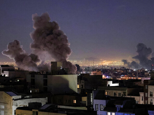TOPSHOT - Smoke plumes rise following missile strikes in Tehran on March 1, 2026. The Unit