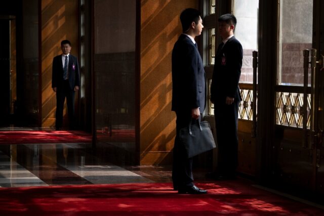 Chinese security wait inside the Great Hall of the People for US President Donald J. Trump