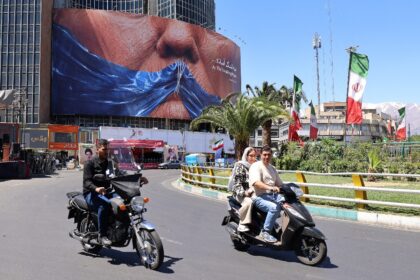 Commuters in Tehran drive past a billboard mocking US President Donald Trump over the Stra