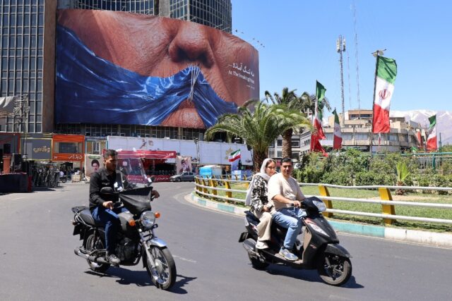 Commuters in Tehran drive past a billboard mocking US President Donald Trump over the Stra