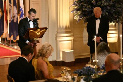 Defense Secretary Pete Hegseth (L) conducts a prayer as US President Donald Trump (R) list