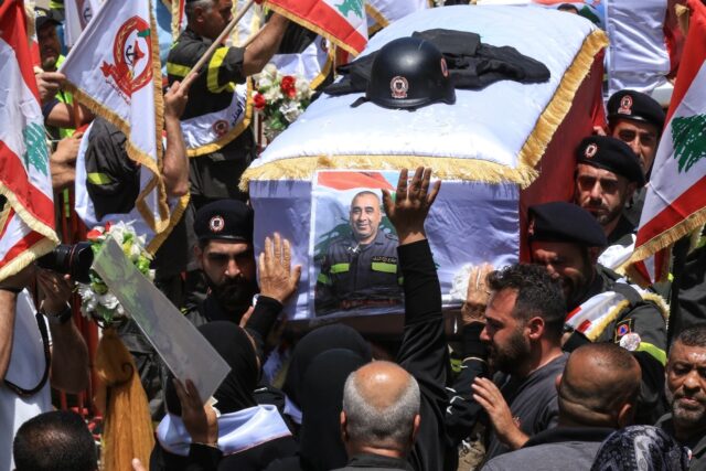 Fellow rescuers carry the coffins of two members of the civil defence who Lebanon said wer