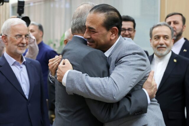 In this handout from Iran's presidency, President Masoud Pezeshkian (C-L) embraces Pa