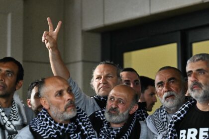 Members of a Gaza-bound flotilla pose outside a terminal following their arrival at Istanb