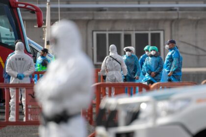 Passengers wearing blue protective suits were evacuated from the cruise ship MV Hondius at