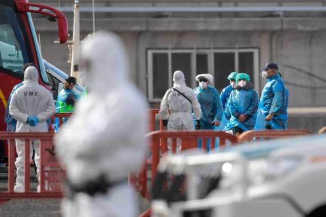 Passengers wearing blue protective suits were evacuated from the cruise ship MV Hondius at