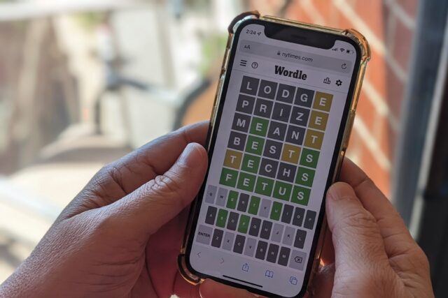This photo illustration shows a person playing online word game Wordle on a mobile phone