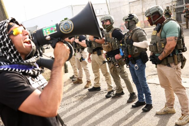 A protester speaks into a megaphone near Delaney Hall, an ICE detention center