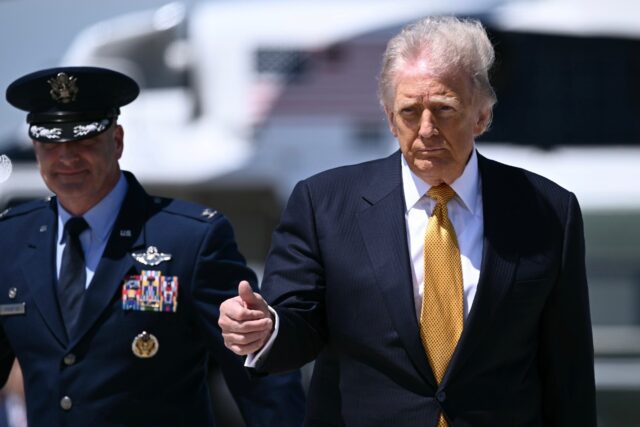 US President Donald Trump gestures prior boarding Air Force One at Joint Base Andrews en r