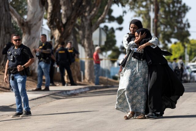 Two women react following a shooting at the Islamic Center of San Diego, in southern Calif