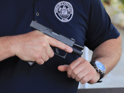 FILE - Kainoa Kaku, president of the Hawaii Rifle Association, checks one of his personal