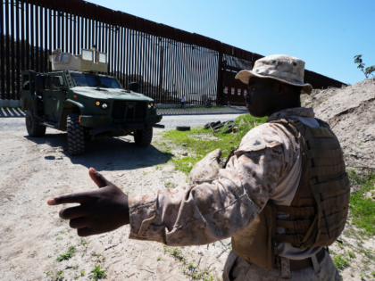 A Marine helps guide a vehicle during a news conference on joint operations involving the