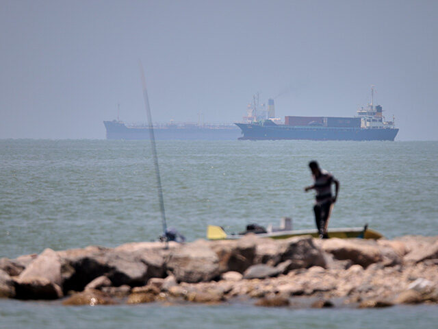 Title: Iran War Strait of Hormuz Image ID: 26168706073921 Article: A man stands beside a f