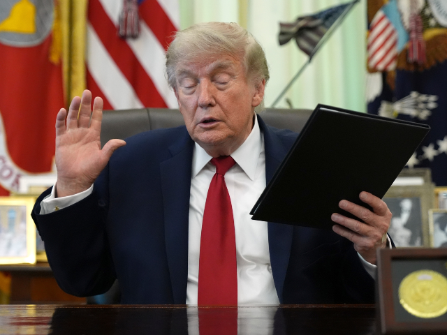 President Donald Trump holds a signed presidential memo to the EPA on pollution control in