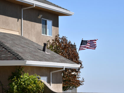 An American flag is seen blowing in the wind on a saved house where firefighters were seen