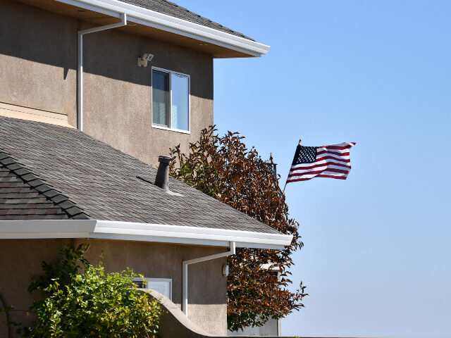 An American flag is seen blowing in the wind on a saved house where firefighters were seen