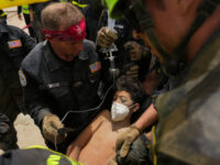 U.S. firefighters from the Fairfax County search and rescue team pull a boy from the rubbl