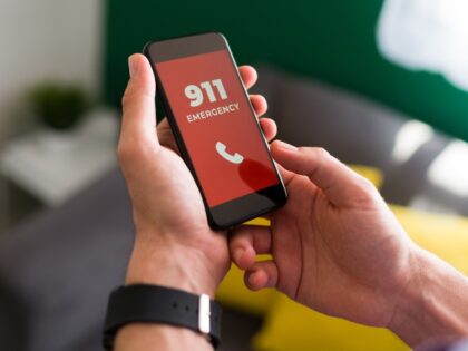 Young person calling 911 on his smartphone after having an emergency or accident at home
