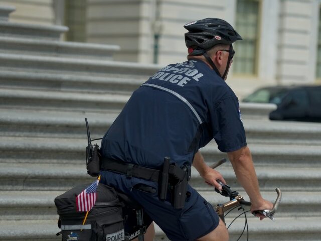 Capitol Police officer on bicycle U.S. Capitol Hill policemen sports an American flag as he patrols the East Front Plaza of