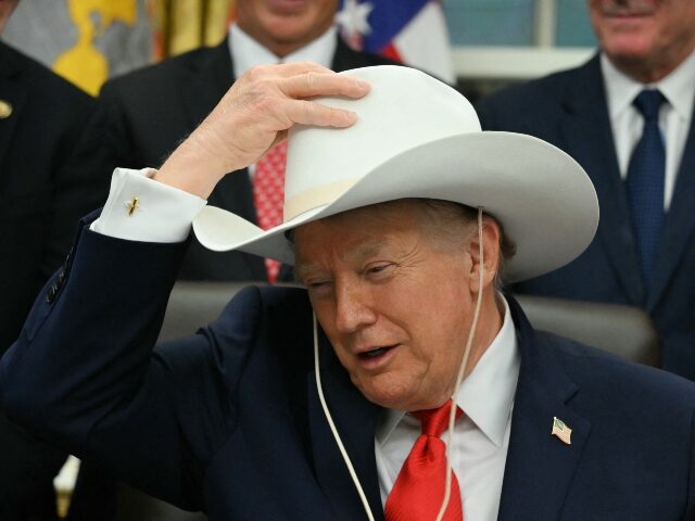 US President Donald Trump puts on a cowboy hat during a bill signing ceremony with members