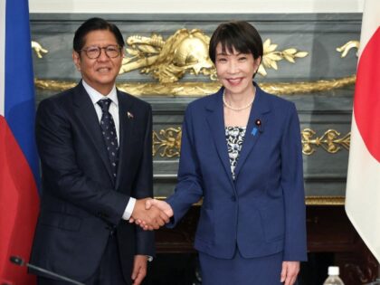 Japan's Prime Minister Sanae Takaichi (R) shakes hands with Philippines' Preside
