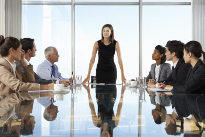 Group Of Business People Having Board Meeting Around Glass Table.