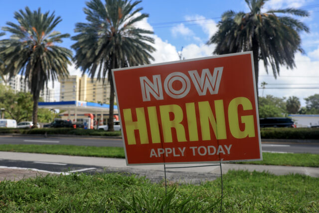 MIAMI, FLORIDA - OCTOBER 03: A 'Now Hiring' sign is posted outside of a business
