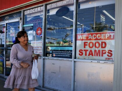 MIAMI, FLORIDA - OCTOBER 31: A 'We Accept Food Stamps' sign hangs in the window