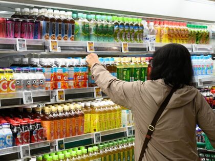 A customer selects a bottle of tea at a Robin Hood store in Ama, Aichi Prefecture, Japan,