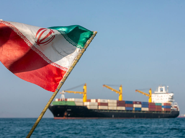 GettyImages-2276029086 STRAIT OF HORMUZ, IRAN - MAY 16: An Iranian flag flutters in the wind as ships remain anch