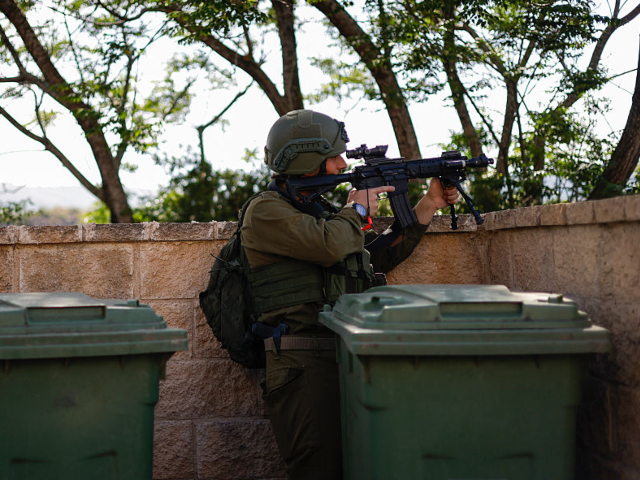 An Israeli soldier reacts after taking cover near the Israel-Lebanon border following a He