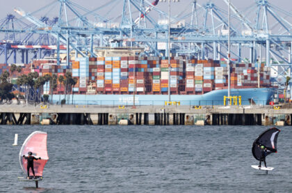 LOS ANGELES, CALIFORNIA - MAY 28: People ride wing foils near a container ship at the Port