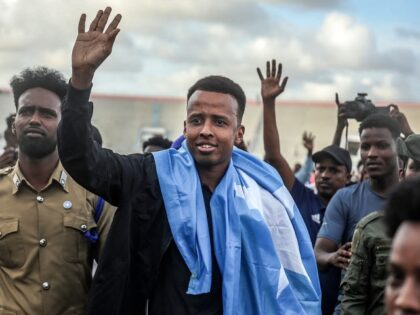 Somali international referee Omar Abdulkadir Artan waves to supporters while draped in the