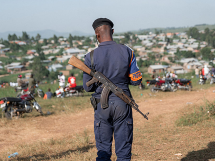 TOPSHOT - A Democratic republic of Congo policeman stands guard at the Nyamurongo cemetery